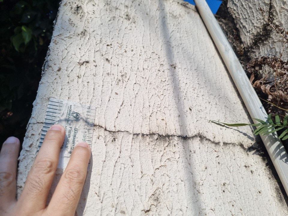 Fissura horizontal em muro de divisa, medida com gabarito antes do in&iacute;cio da obra vizinha. &Eacute; esse registro que responde depois &agrave; pergunta &ldquo;ela j&aacute; estava a&iacute;?&rdquo;.