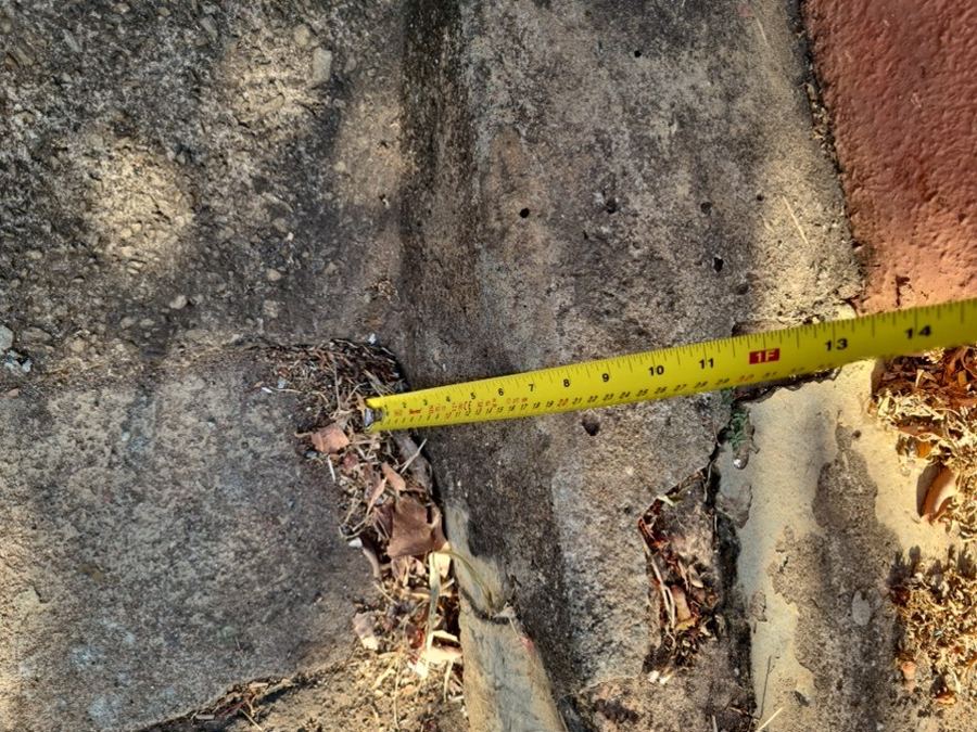 Abertura entre a calçada e o muro de divisa, medida com trena. A dimens&atilde;o registrada &eacute; o que permite comparar o antes e o depois.